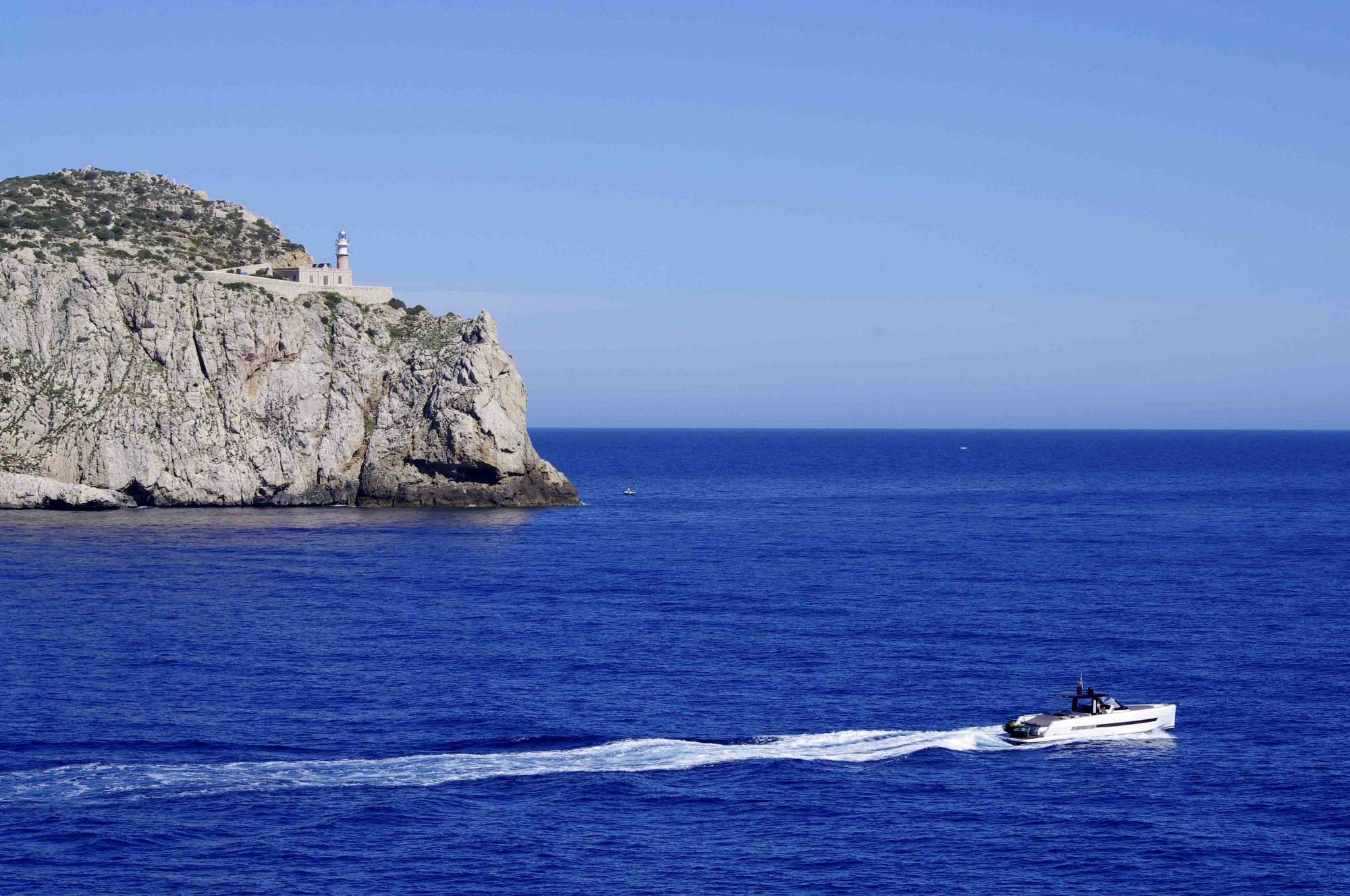 Foto: el faro de Cap de Tramuntana y la barca - San Telmo (Illes Balears), España
