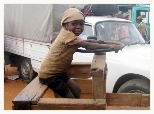 Foto: niño jugando en carreta del padre - Ambalamakana, Madagascar